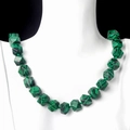 Malachite knotted necklace with faceted green and black striped stone beads on model - Malachite (Synthetic)