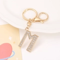 Detailed view of gold 'M' alphabet keychain encrusted with sparkling white rhinestones - Letter M