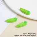 Detailed macro view of miniature green bitter melon charms with realistic resin texture - Bitter Gourd