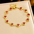 Elegant gold chain bracelet featuring red heart-shaped crystals on warm silk fabric - Red Heart (B1667)