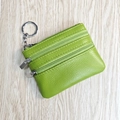 Green leather coin purse with triple zippers and keychain on light wood surface - Lime Green