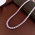 Detailed macro view of glossy lavender pearls on a luxurious dark leather and silk background - 6mm / Purple