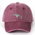 Macro shot of embroidered gray whale on burgundy washed cotton baseball cap texture - Burgundy