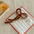 Detailed close-up of brown tortoise shell pattern and hollow bow metal hair claw clip - Burgundy