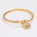 Dettaglio di un bracciale a cavo dorato vintage con ciondolo a moneta tonda e ritratto - Stile Ciondolo Moneta con Ritratto Vintage