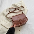 Casual brown leather saddle crossbody bag with gold hardware buckle and adjustable strap - Brown