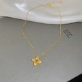 Detailed close-up of textured gold clover pendant with pavé zircon setting and link chain - Gold Hollow Flower