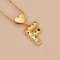 Close-up of gold heart pendant necklace featuring letter F with colorful zircon stones - Letter F / Gold