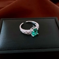 Vista detallada del anillo verde esmeralda con diseño de rombos sobre joyero negro - Estilo de Rombos Acolchados Abiertos (WR384) / Plata-Verde