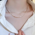 Collana doppia argentata con perle quadrate indossata su una camicia bianca - Argento a Doppio Strato