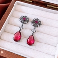 Close-up of vintage teardrop red gemstone earrings with intricate black filigree detail - Vintage Ruby Red Waterdrop Dangle (Silver Pin - Gunmetal - Red)