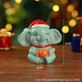 Christmas elephant resin figurine in green with festive red hat and orange candy gift - Elephant