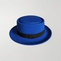 Royal blue pork pie hat with flat crown and black decorative band on gray background - 57cm / Blue