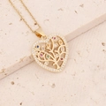 Detailed close-up of golden heart pendant with tree of life and colorful zircon inlay - Tree of Life Heart