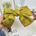 Macro shot of an olive green satin oversized bow hair clip with premium silk luster texture - Ginger Yellow (Spring Clip)