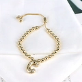 Detail of golden bead bracelet featuring a sparkling rhinestone-encrusted letter C charm - Letter C