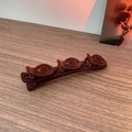 Detail of dark brown flocked hair clip featuring three decorative 3D rose ornaments - Brown