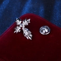 Silver cross-shaped brooch with leaf details shown on red velvet with metal clasp - Silver Decorative Cross