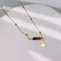 Dettaglio della collana d'oro con pietra occhio di tigre marrone e ciondolo a stella - Acciaio Inossidabile + Occhio di Tigre / Stella a otto punte