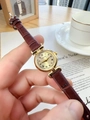 Close-up of vintage gold quartz watch with brown leather strap and roman numeral dial - Brown Faux Leather Strap