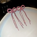 Macro di orecchini a fiocco rosa con nappe di strass sul bordo del piatto bianco - Perno per orecchini in argento - Rosa