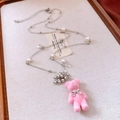 Détail d'un pendentif ours rose floconneux avec perles élégantes et nœud argenté sur chaîne - Argent-Rose