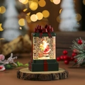 Nahaufnahme einer Weihnachtsmann-Schneekugel in grüner Geschenkbox mit roter Schleife - Grün Weihnachtsmann