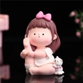 Resin cartoon girl figurine with pink bow and white cat sitting on black background - B105-B Leg Stretch Front