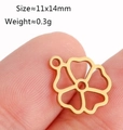 Gold stainless steel hollow flower pendant charm 11x14mm shown on a fingertip for scale - Hollow Flower / Gold