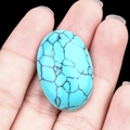 Oval blue turquoise stone bead with natural black veins held for jewelry inlay - Blue Turquoise (Synthetic)