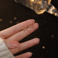 Orecchini a perno con fiocco in argento sterling S999 dorato indossati sul lobo - Oro / Argento 999