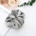 Detail of silver gray satin scrunchie with silk texture on white background - Gray