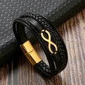 Détail macro d'un bracelet multicouche en cuir avec symbole infini et fermoir magnétique - Noir + Or