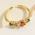 Close-up of 14K gold-plated wavy ring set with five colorful gemstones on light surface - Geometric / Colorful Zirconia