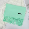 Écharpe en cachemire vert menthe avec pompons et étiquette sur fond de dentelle blanche - 70×200cm / Vert d'Eau