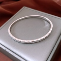 Close-up of silver-plated clasp bangle with engraved diamond pattern and cubic zirconia - Quilted Zirconia Buckle Style / Silver (18K Gold Plated)