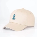 Dettaglio del ricamo a forma di dinosauro color verde su un cappellino in cotone beige - Beige