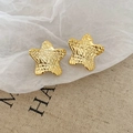 Macro detail of star-shaped golden stud earrings featuring a vintage textured grid pattern - Quilted Star Style (HE27805) / Gold