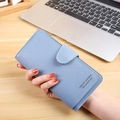 Portafoglio lungo azzurro da donna con fibbia e morbida texture opaca nella mano - Blu