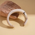 Detail showing the brown marble texture on a thick acrylic cuff bracelet with high gloss - White
