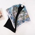 Retro 90cm floral print silk scarf in blue and green draped on a black knit top - Jungle Light Blue