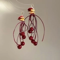 Dettaglio di orecchini a nappe rosse con perline di corallo e accenti di conchiglia - Stile con Nappa Intrecciata Rossa