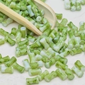 Vue détaillée de perles en marbre vert en forme de bambou versées par une cuillère - Style Bambou (J166#)