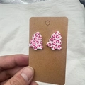 Gros plan de boucles d'oreilles sapin de Noël en acrylique à motif léopard rose sur papier - Boucles d'oreilles clous / Rose