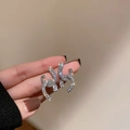 Macro shot of silver stud earrings with interlocking C shape and micro-inlaid crystals - Silver Needle Rhinestone Stud Earrings (HE7664)