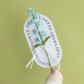 Handmade crochet blue lily flower with white ribbon and gift tag on green backdrop - Forget-me-not - Light Blue