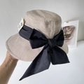 Detail of linen sun hat with large black silk bow and UV care protective label - Beige