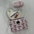 Detailed close-up of a pink quilted makeup bag with a black bow and heart accessories - Long Style Bow Print / Pink