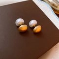 Gros plan détaillé des boucles d'oreilles perles élégantes avec finition dorée mate - Doré