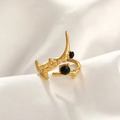 Detail of gold hammer-textured ring with two black stones on white silk fabric - Black Zirconia Ring / Gold